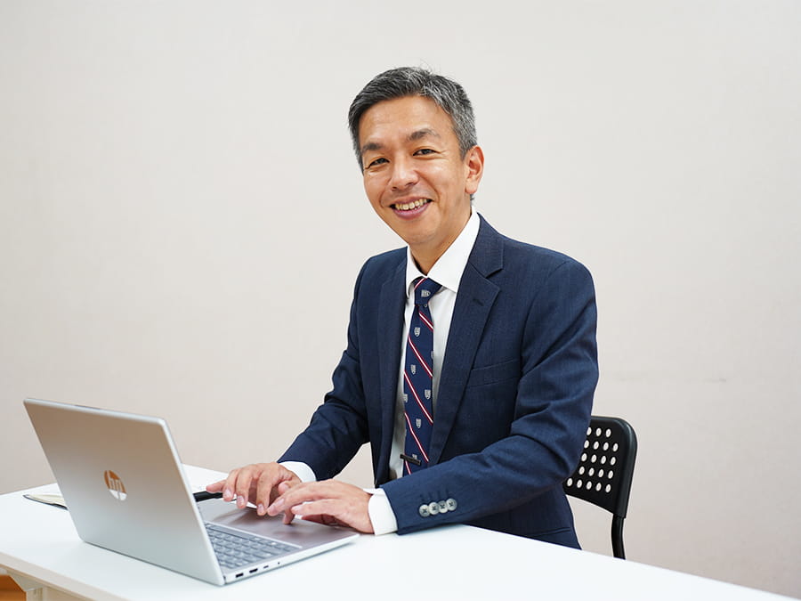 ほほ笑みながら、仕事に励む事務所代表