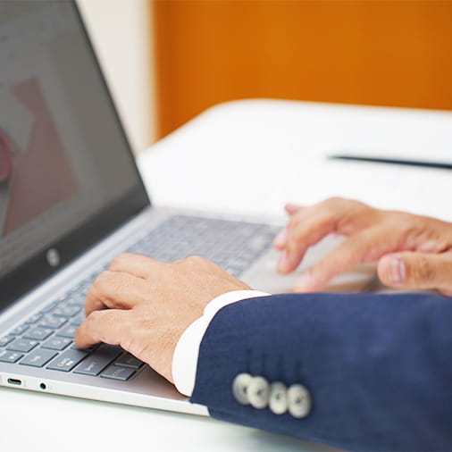 パソコンの操作をしながら書類を作成する代表の手元