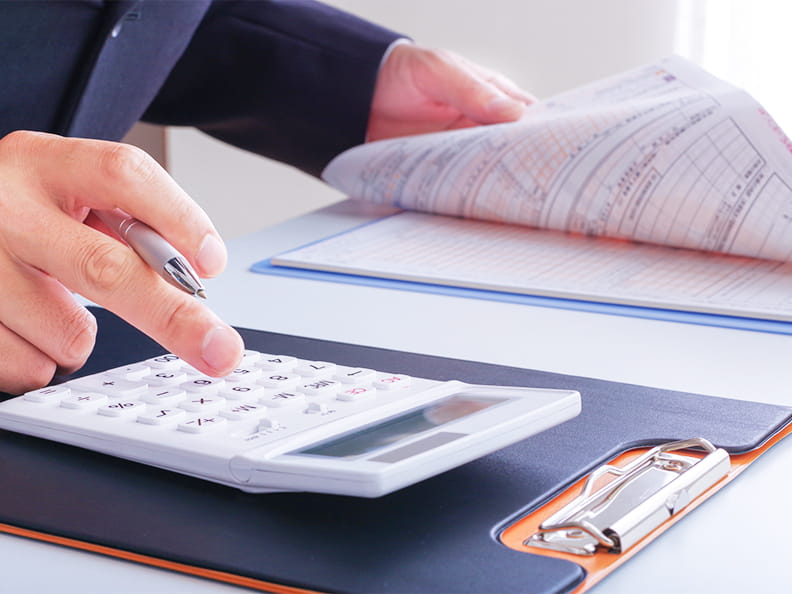 書類を確認しながら電卓を使い計算していく様子