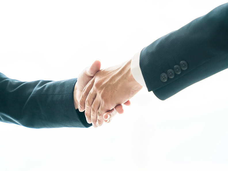 スーツを着た男性が握手をする様子